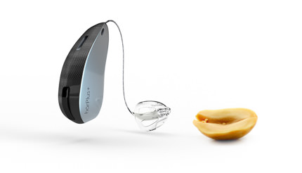 Hinter-dem-Ohr-Hörgerät neben einer Erdnuss im Größenvergleich